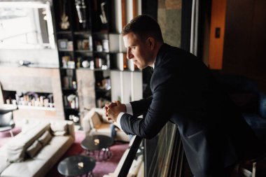 Otel içinde mavi smokinli damadın portresi.