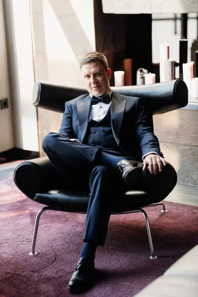 Otel içinde mavi smokinli damadın portresi.