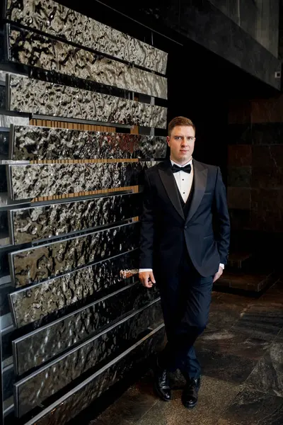 Otel içinde mavi smokinli damadın portresi.