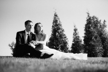 Gelin ve damat gün batımında parkta yürüyor.