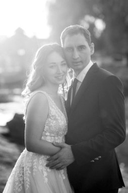 Gelin ve damat gün batımında parkta yürüyor.