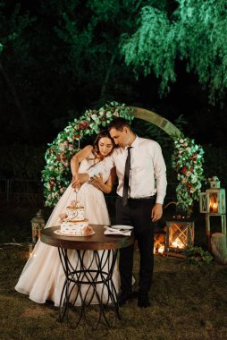 newlyweds happily cut, laugh and taste the wedding cake