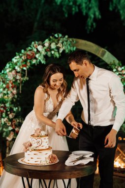 newlyweds happily cut, laugh and taste the wedding cake