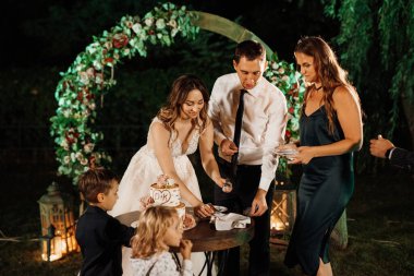 newlyweds happily cut, laugh and taste the wedding cake