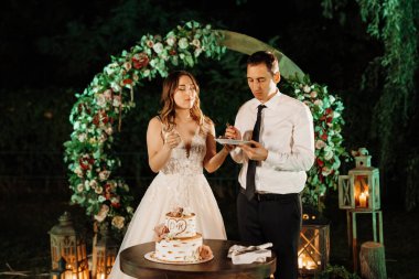 newlyweds happily cut, laugh and taste the wedding cake