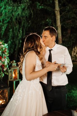 newlyweds happily cut, laugh and taste the wedding cake