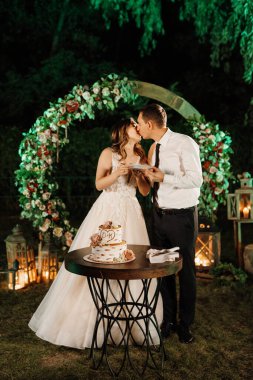 newlyweds happily cut, laugh and taste the wedding cake