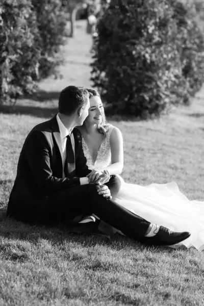 Gelin ve damat gün batımında parkta yürüyor.