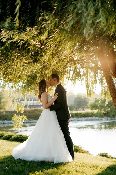 Gelin ve damat gün batımında parkta yürüyor.