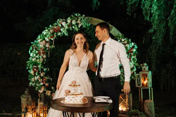 newlyweds happily cut, laugh and taste the wedding cake