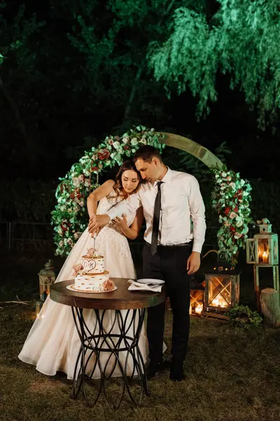 newlyweds happily cut, laugh and taste the wedding cake