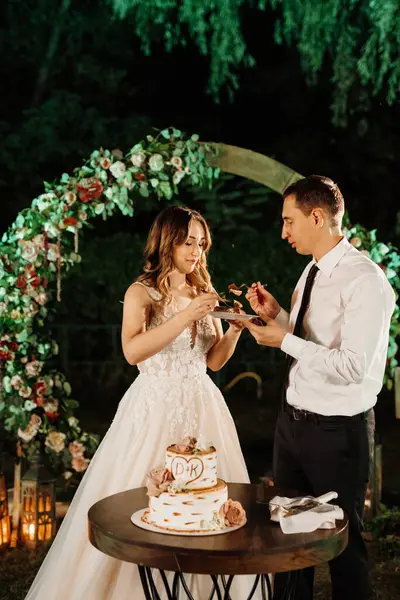 newlyweds happily cut, laugh and taste the wedding cake
