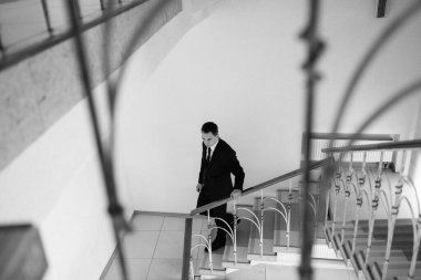 Siyah takım elbiseli ve kravatlı genç bir adamın portresi.