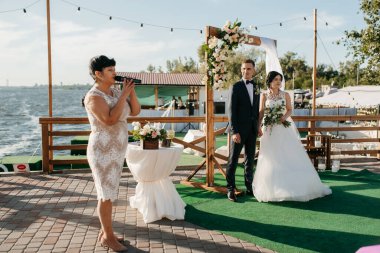 Nehrin yakınındaki yüksek bir rıhtımda davetlilerle düğün töreni.