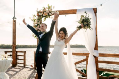 Nehrin yakınındaki yüksek bir rıhtımda davetlilerle düğün töreni.