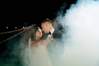 Gelin ve damadın ağır dumanlı bir restoranda ilk dansı.