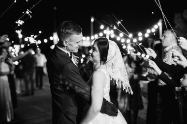 newlyweds at a wedding in the corridor of sparklers