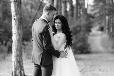 Genç bir çift, bir adam ve bir kız nehir kenarındaki yeşil tepeler boyunca yürüyorlar.