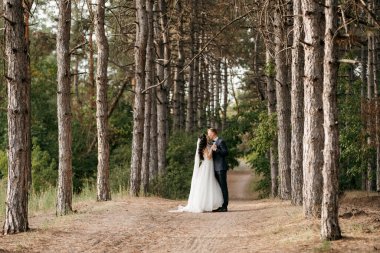 Genç bir çift, bir adam ve bir kız nehir kenarındaki yeşil tepeler boyunca yürüyorlar.
