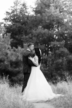 Genç bir çift, bir adam ve bir kız nehir kenarındaki yeşil tepeler boyunca yürüyorlar.