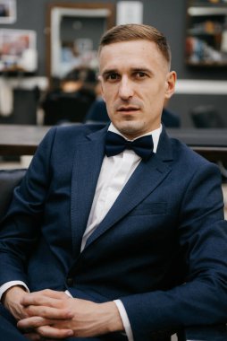 Berber dükkanındaki eğitim kampında tıraş olmuş ve stil yapmış genç bir adamın portresi.