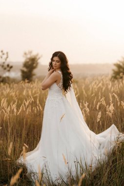 Kız nehir kenarındaki yeşil tepeler boyunca yürüyor.