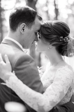 portrait of an elegant groom in a blue suit in a deciduous forest with a bouquet