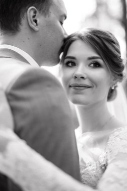 portrait of an elegant groom in a blue suit in a deciduous forest with a bouquet