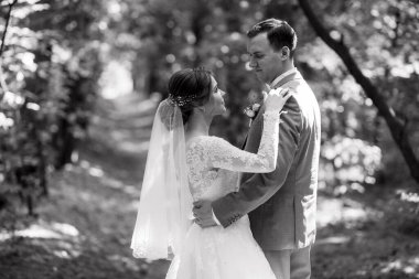 portrait of an elegant groom in a blue suit in a deciduous forest with a bouquet