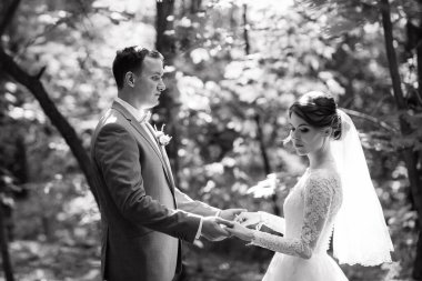 portrait of an elegant groom in a blue suit in a deciduous forest with a bouquet