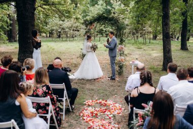 Bir adamla bir kızın düğün seremonisi Orman yolunda bir kemerin arka planına karşı