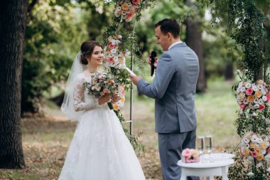 Bir adamla bir kızın düğün seremonisi Orman yolunda bir kemerin arka planına karşı