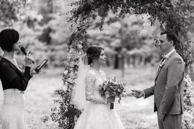 Bir adamla bir kızın düğün seremonisi Orman yolunda bir kemerin arka planına karşı