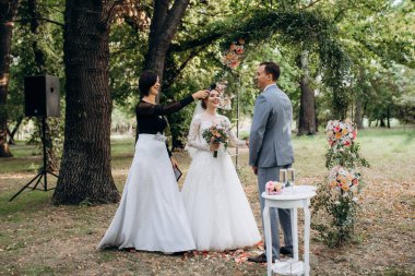 Bir adamla bir kızın düğün seremonisi Orman yolunda bir kemerin arka planına karşı