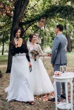 Bir adamla bir kızın düğün seremonisi Orman yolunda bir kemerin arka planına karşı