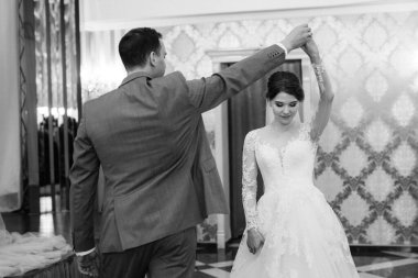 Gelin ve damadın ilk düğün dansı gün batımında restoranın içinde.