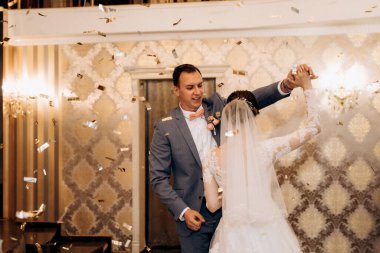 Gelin ve damadın ilk düğün dansı gün batımında restoranın içinde.