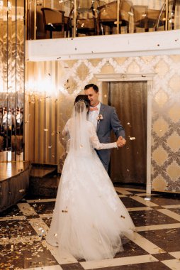 Gelin ve damadın ilk düğün dansı gün batımında restoranın içinde.