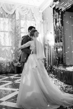 Gelin ve damadın ilk düğün dansı gün batımında restoranın içinde.