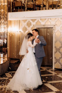 Gelin ve damadın ilk düğün dansı gün batımında restoranın içinde.