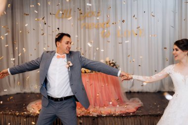 Gelin ve damadın ilk düğün dansı gün batımında restoranın içinde.