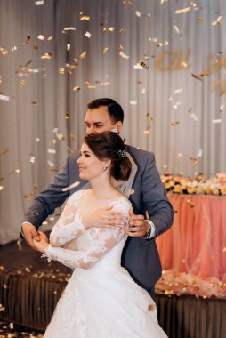 Gelin ve damadın ilk düğün dansı gün batımında restoranın içinde.