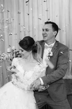 Gelin ve damadın ilk düğün dansı gün batımında restoranın içinde.