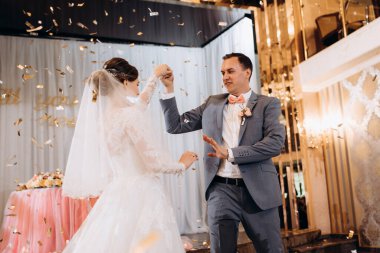 Gelin ve damadın ilk düğün dansı gün batımında restoranın içinde.