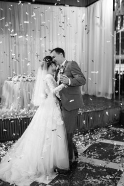 Gelin ve damadın ilk düğün dansı gün batımında restoranın içinde.