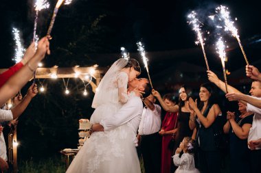 Pasta mumlarından ve havai fişeklerden çıkan soğuk ateş yeni evlilerin ellerindeydi.