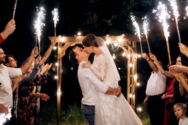 Pasta mumlarından ve havai fişeklerden çıkan soğuk ateş yeni evlilerin ellerindeydi.