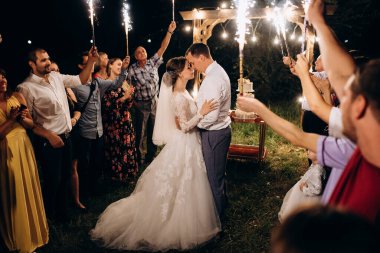 Pasta mumlarından ve havai fişeklerden çıkan soğuk ateş yeni evlilerin ellerindeydi.