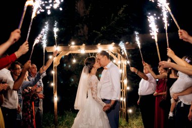 Pasta mumlarından ve havai fişeklerden çıkan soğuk ateş yeni evlilerin ellerindeydi.