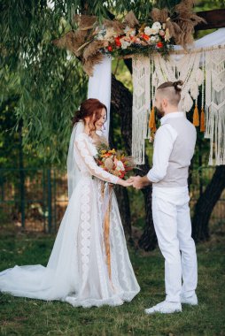 Ormandaki yeşil bir çayırda aşık genç bir çiftin düğün töreni.